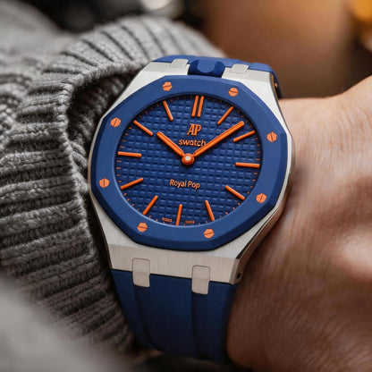 Blue and silver Royal Pop watch shown on a wrist with a knit sleeve.